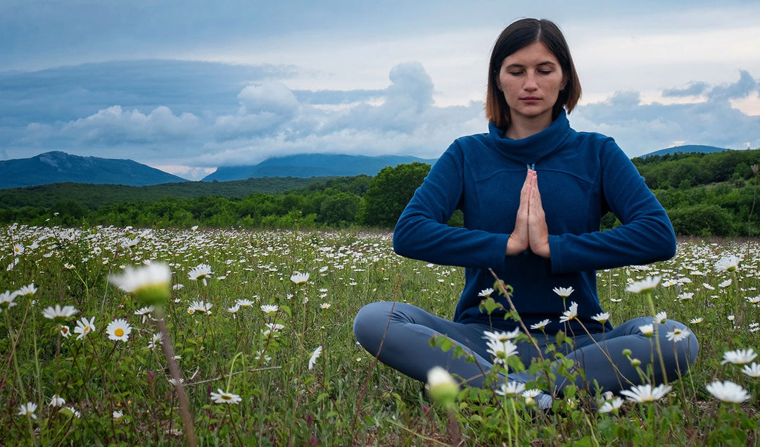 woman meditating in a field of spring flowers